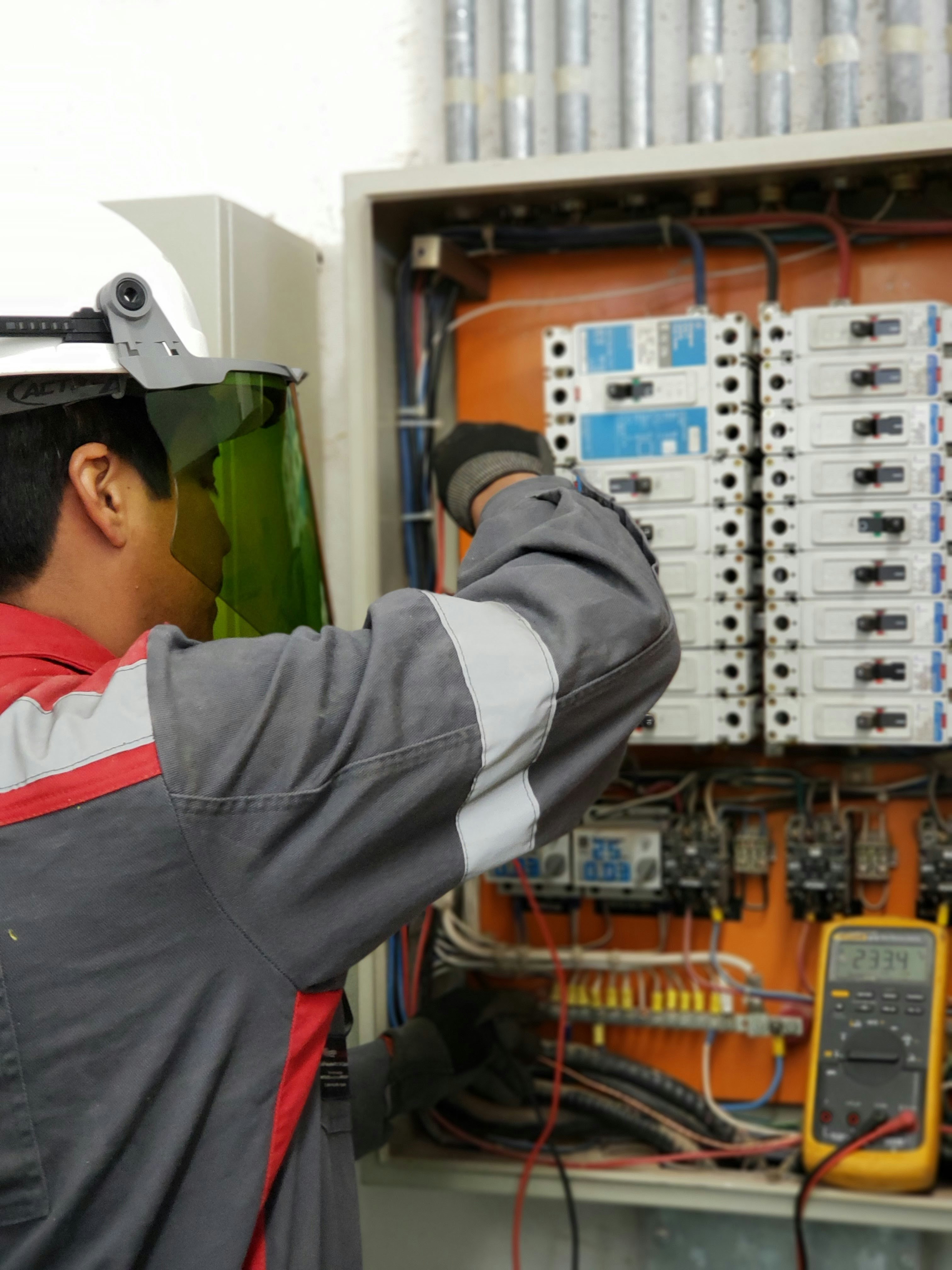 Technician inspecting an AC contactor for maintenance