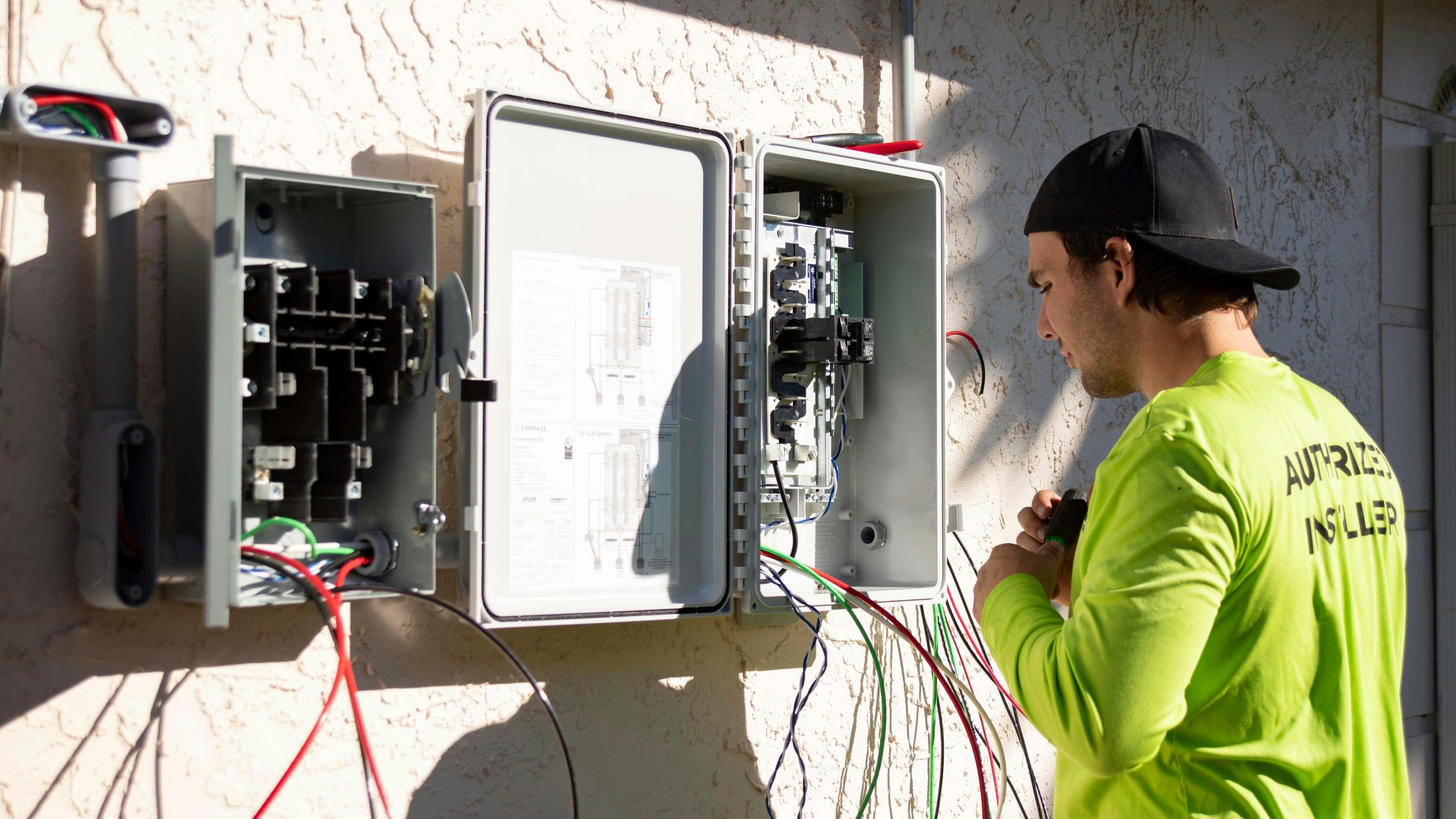 Electrical technician using safety equipment while handling a contactor
